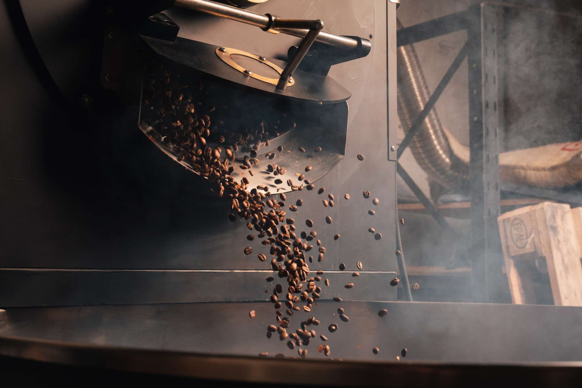 Freshly roasted coffee beans pouring out of the roaster